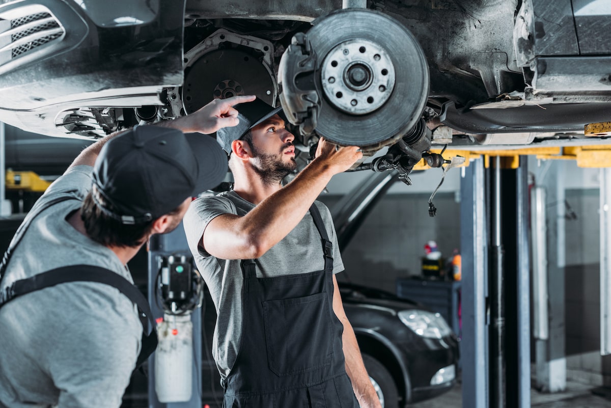 mechanics working at auto repair shop with warranty